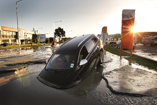 Новая Зеландия, г. Крайстчерч, 13 июня 2011 г.: машина упала в воду на ул.Ферри после втого толчка магнитудой 6,0 баллов. Фото: Martin Hunter/Getty Images