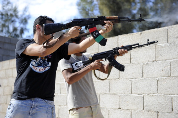 Війська НПС Лівії обстрілюють сили Муаммара Каддафі з-за стіни в місті Сирт, 16 жовтня 2011 року. Фото: PHILIPPE DESMAZES/AFP/Getty Images