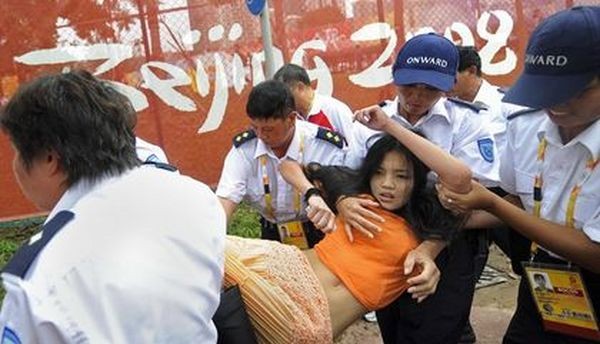 Поліцейські заарештовують дівчину, яка спробувала під час олімпійських змагань висловити протест проти придушення китайською компартією тибетців. 9 серпня. Гонконг. Фото: DAVID HECKER/AFP/Getty Images 