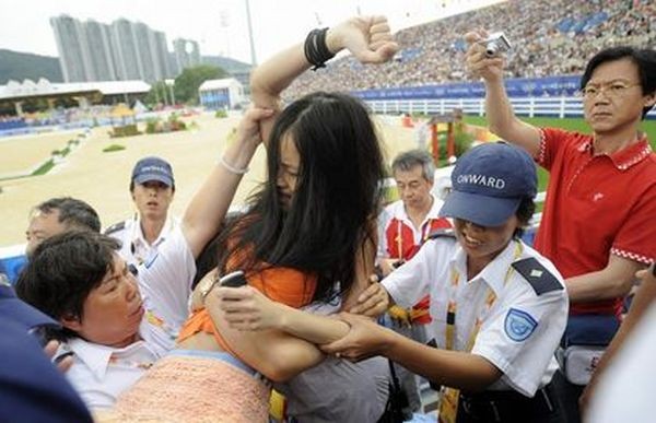 Поліцейські заарештовують дівчину, яка спробувала під час олімпійських змагань висловити протест проти придушення китайською компартією тибетців. 9 серпня. Гонконг. Фото: DAVID HECKER/AFP/Getty Images 