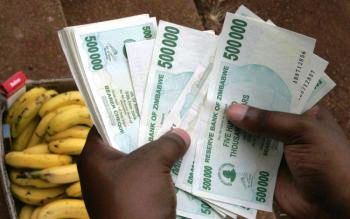 Мешканець Зімбабве відраховує пачку банкнот, щоб купити кілька бананів. Тривала економічна криза призвела до найвищого рівня інфляції в світі. Фото: Alexander Joe/AFP/Getty Images