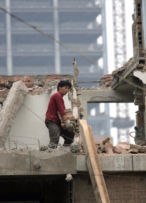 Китайські робітники руйнують старі житлові приміщення. Фото: GOH CHAI HIN/AFP/Getty Images 