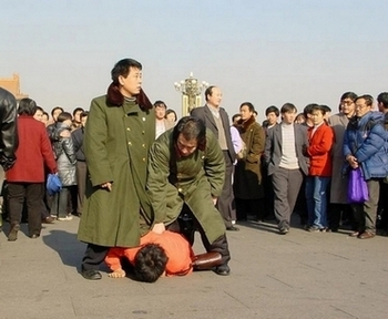 Китайские сотрудники спецслужбы прямо на улице арестовывают последователя Фалуньгун. Фото с minghui.com