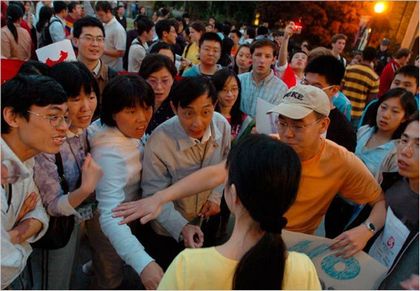 Ван Ченюань, оточена китайцями, що підтримують політику компартії, намагається закликати їх до мирного діалогу і обговорення. Фото з epochtimes.com