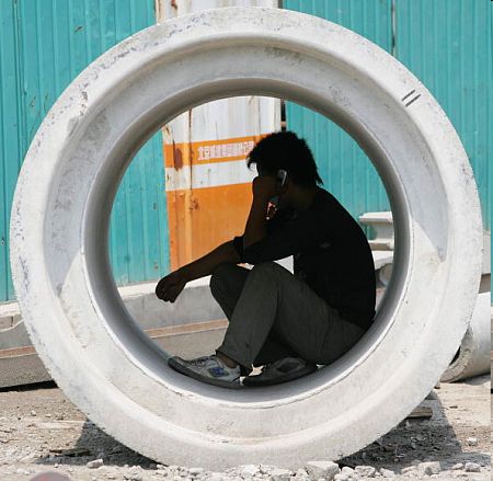Робітник розмовляє по мобільному. Фото: Guang Niu/getty Images