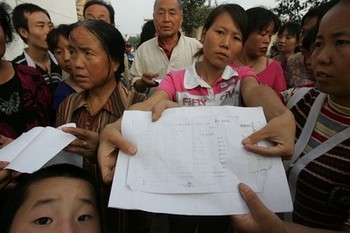 Люди показують медичні висновки, в яких вказана ступінь отруєння свинцем. Фото з epochtimes.com