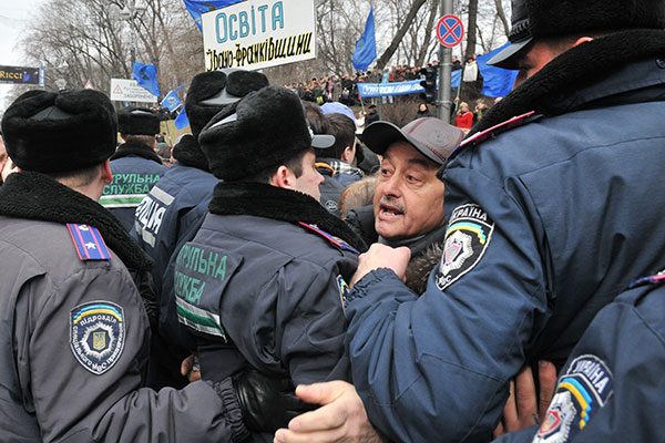 Міліція витісняє з проїжджої частини учасника акції працівників сфери освіти і науки з вимогою підвищення зарплати біля Кабінету Міністрів України 22 березня 2011 року. Фото: Володимир Бородін/The Epoch Times Україна