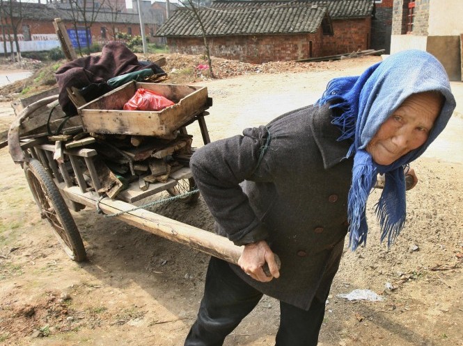 Пожилая китаянка везет на повозке дрова для приготовления пищи, побережье реки Янцзы, город Цзюцзян, 7 марта 2007 года. Фото: Mark Ralston/AFP/Getty Images
