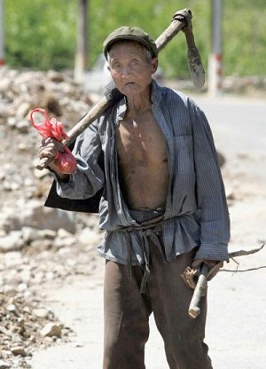 Пожилой китайский крестьянин бредет по дороге в предместьях Пекина. Фото: STR/AFP/Getty Images