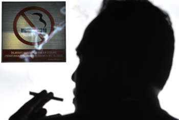 Несмотря на то, что в феврале 2006 года был принят строгий закон, запрещающий курение в определенных местах, часто возле надписи “не курить” можно увидеть курящих людей. Фото: Getty Images