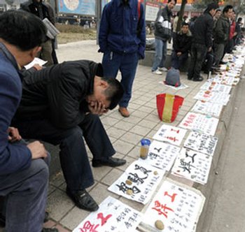 Рабочие-мигранты на обочине дороги разложили объявления о поиске работы. Город Ченду провинции Сычуань. Фото: Getty Images