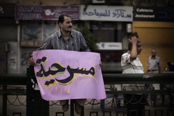 Египтянин держит плакат, на котором написано «Это фарс», во время демонстрации на площади Тахрир против результатов президентских выборов. 29 мая 2012 г. Фото: MARCO LONGARI/AFP/GettyImages