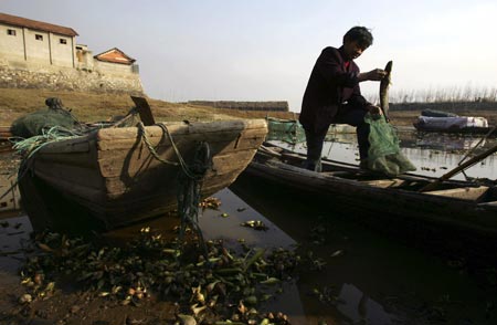 Після лову рибак витягує рибу із сітки. Фото: Photo by China Photos/Getty Images