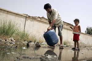 Беженец из Ирака набирает воду в бак из поврежденной трубы. Фото: Sabah Arar/AFP/Getty Images