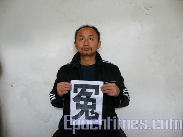 Апеллянт из г.Ухань Чен Минкуан. На листе написан иероглиф, обозначающий «несправедливо обиженный». Фото: The Epoch Times