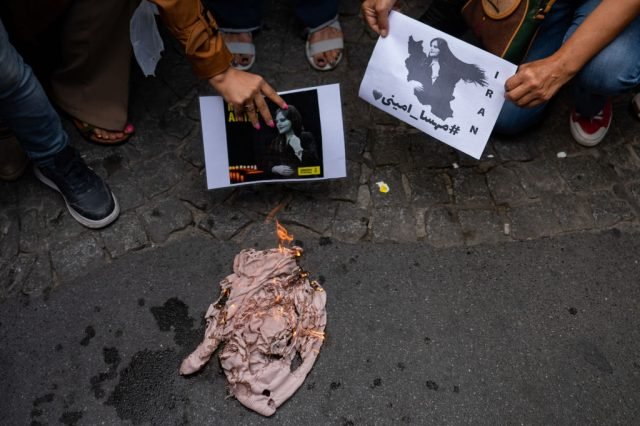 Іранські жінки символічно спалюють свої хустки на знак протесту проти ісламського дрес-коду.(YASIN AKGUL/AFP via Getty Images)