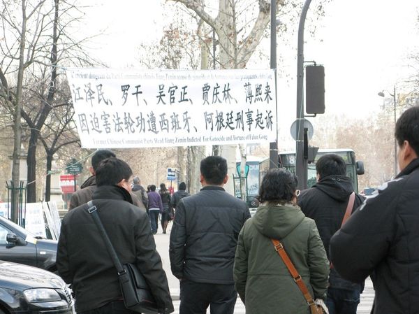 Группа китайских туристов остановилась возле баннера, обсуждая увиденное. (Hao Yang/The Epoch Times)