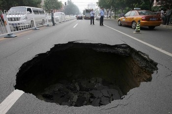 Посередине дороги пекинского района Чаоян образовалась яма. 27 июля 2009 год. Фото: epochtimes.com