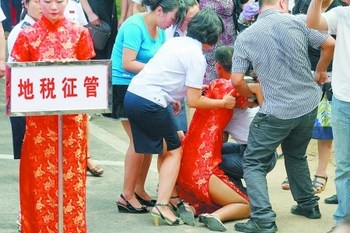 Во время церемонии открытия спартакиады девушки с табличками падают в обморок из-за жары. Фото с kanzhongguo.com