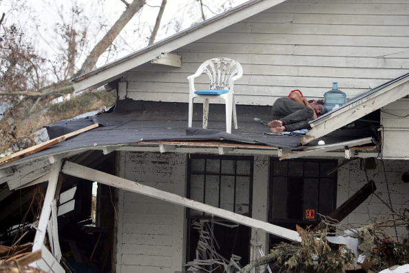 Человек спит на крыше своего дома после урагана Катрина, Билокси, штат Миссисипи. Фото: Joe Raedle/Getty Images