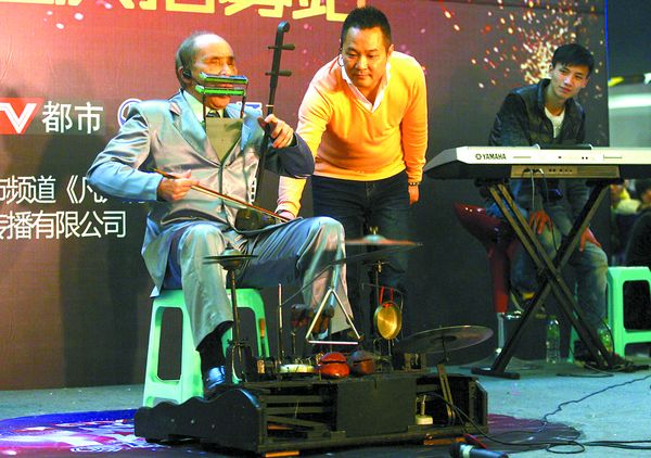Вэнь Хуацюн исполняет народную мелодию, играя одновременно на 15 инструментах. Фото: cqcb.com
