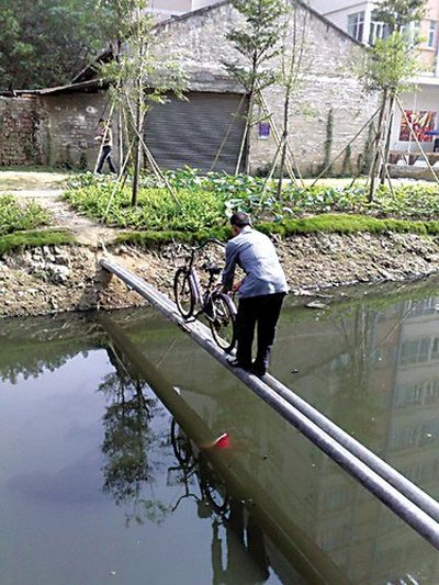 Каждый день жители деревни вынуждены переправляться через речку по узкому мосту из двух труб. Фото: epochtimes.com