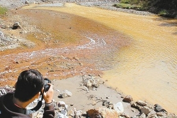 В результате утечки отходов предприятия, вода в реке Хуанлунхэ стала мутной и разноцветной. Провинция Шэньси. 14 октября 2010 год. Фото: epochtimes.com