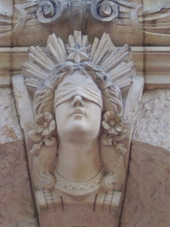 Юстиция, римская богиня правосудия изображена с повязкой на глазах, с весами и мечом, на воротах окружного суда в Германии. (Jan von Brцckel/Pixelio)