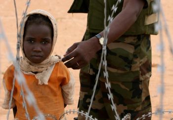 Девочка смотрит сквозь колючую проволоку на суданскую базу миссии Африканского Союза, расположенной в Лабардо в южном Дарфуре. Фото: Stuart Price/AFP/Getty Images