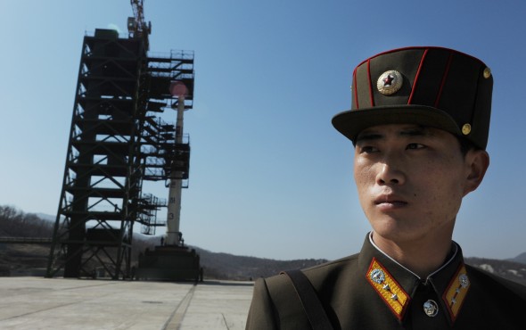 Солдат Северной Кореи охраняет ракету Unha-3 rocket при космическом центре Tangachai-ri, апрель, 2012 год. Фото: Pedro Ugarte/AFP/Getty Images
