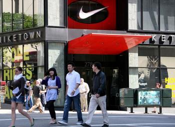 Пешеходы проходят мимо магазина Niketown. Сан-Франциско, штат Калифорния. Пара Nike в магазине США стоит в среднем $35, а в Пекине - $120. Фото: Justin Sullivan/Getty Images