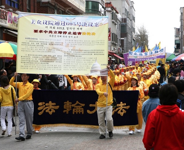 Плакат с вступлением к «Девяти комментариям», позади колонна барабанщиков. Фото: Xi Tai/The Epoch Times