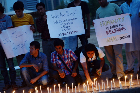 Пакистанцы зажгли свечи в честь погибших альпинистов. На плакате надпись: «Извините, мы не могли их спасти». Фото: FAROOQ NAEEM / AFP / Getty Images