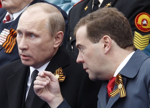 Владимир Путин (слева) и Дмитрий Медведев смотрят Парад Победы на Красной площади в Москве 9 мая 2012 года. Фото: VLADIMIR RODIONOV/AFP/GettyImages