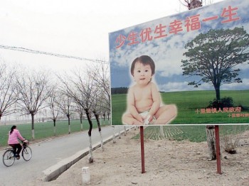 Реклама на билборде, размещённая по заказу китайского бюро по планированию семьи, гласит: «Меньше родов, но более здоровых, принесёт жизненное счастье». Фото: AFP/Getty Images