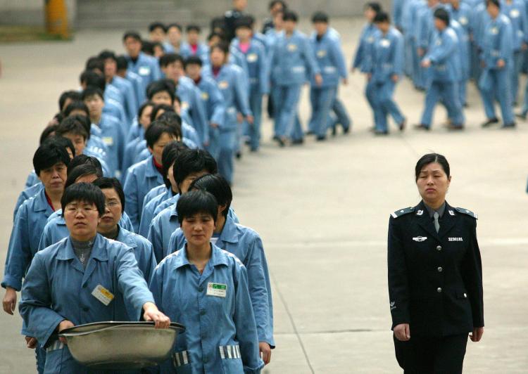 Наньцзин, КНР. 2005 год. Охрана сопровождает заключённых в тюрьме в день открытых дверей. Последнее время в Китае появляются призывы закрыть трудовые лагеря. Фото: STR/AFP/Getty Images