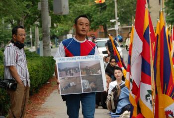 Житель Тибета выступает с акцией протеста перед китайским консульством в Торонто. У него в руках фотографии жителей Тибета, погибших от разрывных пуль. Фото: Мэтью Литл/The Epoch Times
