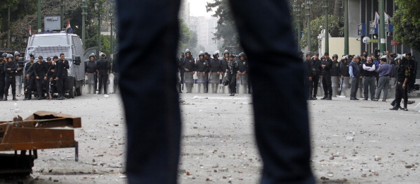 Египетский протестующий стоит напротив полиции возле площади Тахрир, 24 января 2012 г. Каир, Египет. Фото: MOHAMMED ABED/AFP/Getty Images