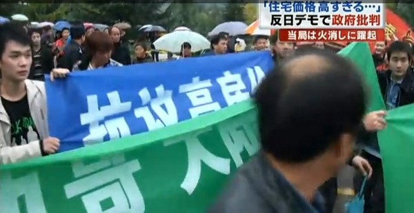 Во время антияпонской акции протеста появились плакаты против высоких цен на квартиры, коррупции и т.д. Кадр видеоролика японского телевидения