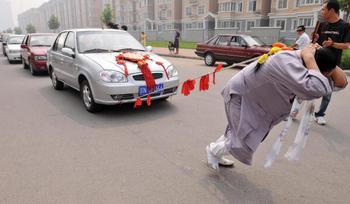 Китаянка Чжан Тинтин протянула на своей косе 6 автомобилей. Фото: AFP/Getty Images 