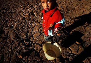 В Китае разразилась сильная засуха. На фото мальчик стоит на засохшем поле в районе города Кунмин провинции Юньнань. 2 февраля 2010 года. Фото: STR/AFP/Getty Images