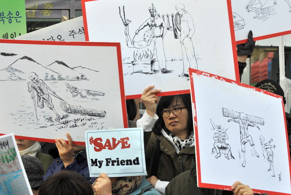Южнокорейские активисты держат плакаты, изображающие наказания в КНДР. Митинг 9 марта 2012 года возле китайского посольства в Сеуле, осуждающий репатриации Пекином северокорейских беженцев. Фото: JUNG YEON-JE/AFP/Getty Images