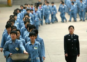 Заключённые в сопровождении полиции в день открытых дверей тюрьмы Нанкина. Китай, 11 апреля 2005 года. Недавно в провинции Гуандун наметили план ликвидации лагерей принудительного труда. Фото: STR/AFP/Getty Images