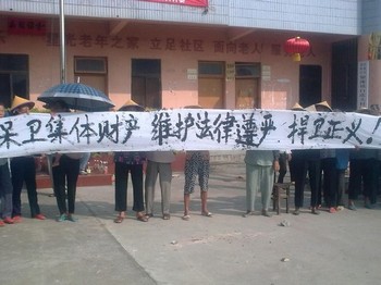 Крестьяне деревни Байхутоу держат плакат с надписью: «Защитим коллективную собственность, защитим авторитет закона, защитим справедливость». Фото предоставлено крестьянами