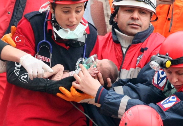 Турецькі рятувальники тримають двотижневу дівчинку Азру Карадуман, яку дістали з-під уламків будівлі, що обрушилося в результаті землетрусу. Еріш, 25 жовтня 2011 року. Фото: Adem Altan/Getty Images