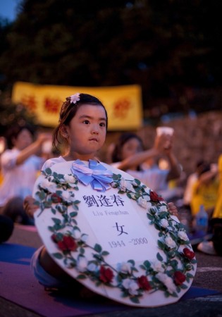 Нью-Йорк, США. Девочка держит табличку с именем одного из последователей Фалунь Дафа, который был замучен до смерти в ходе репрессий в отношении последователей Фалунь Дафа в Китае. Фото: Великая Эпоха