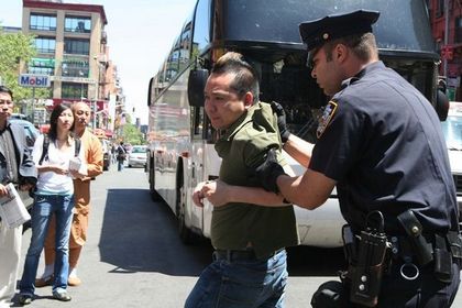 Полицейский арестовал напавшего на последовательницу Фалуньгун китайца. Фото: The Epoch Times