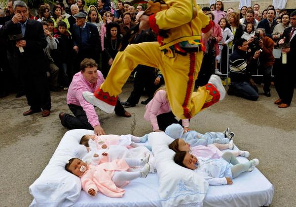 Цермонии Эль Колачо (El Colacho). Одетый как дьявол, мужчина, перепрыгивает через младенцев. Фото: Denis Doyle/Getty Image