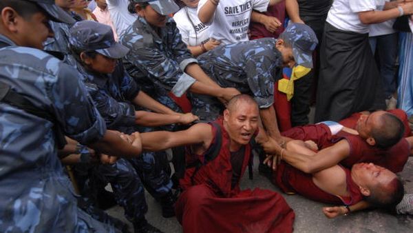 Непальські поліцейські затримують тибетських активістів під час демонстрації біля китайського консульства. Фото: AFP PHOTO/Prakash MATHEMA