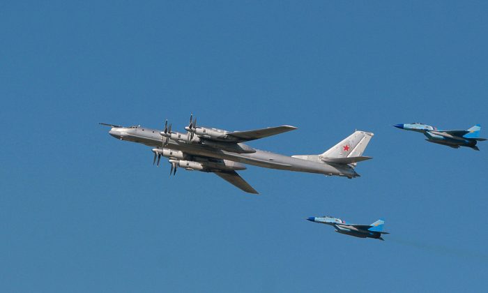 Российский стратегический бомбардировщик ТУ-95 в окружении самолетов МиГ-29. (AFP/Getty Images)